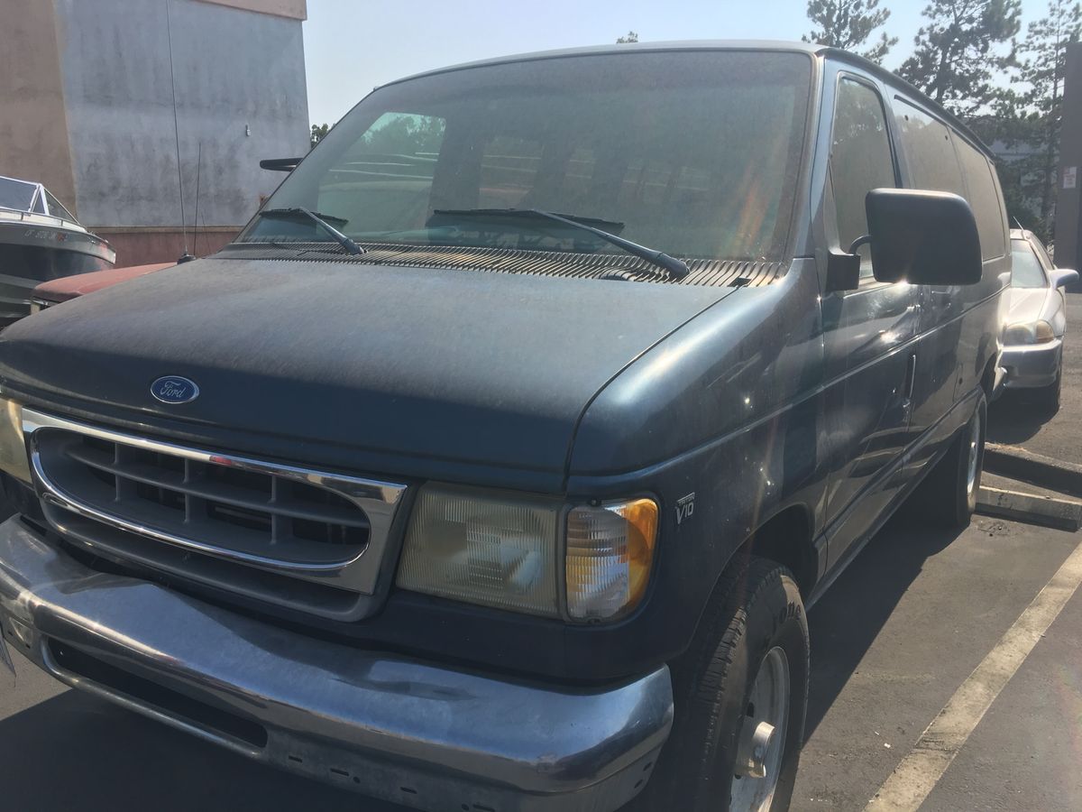 A stock dark-blue 1997 Ford E350 van in a parking lot
