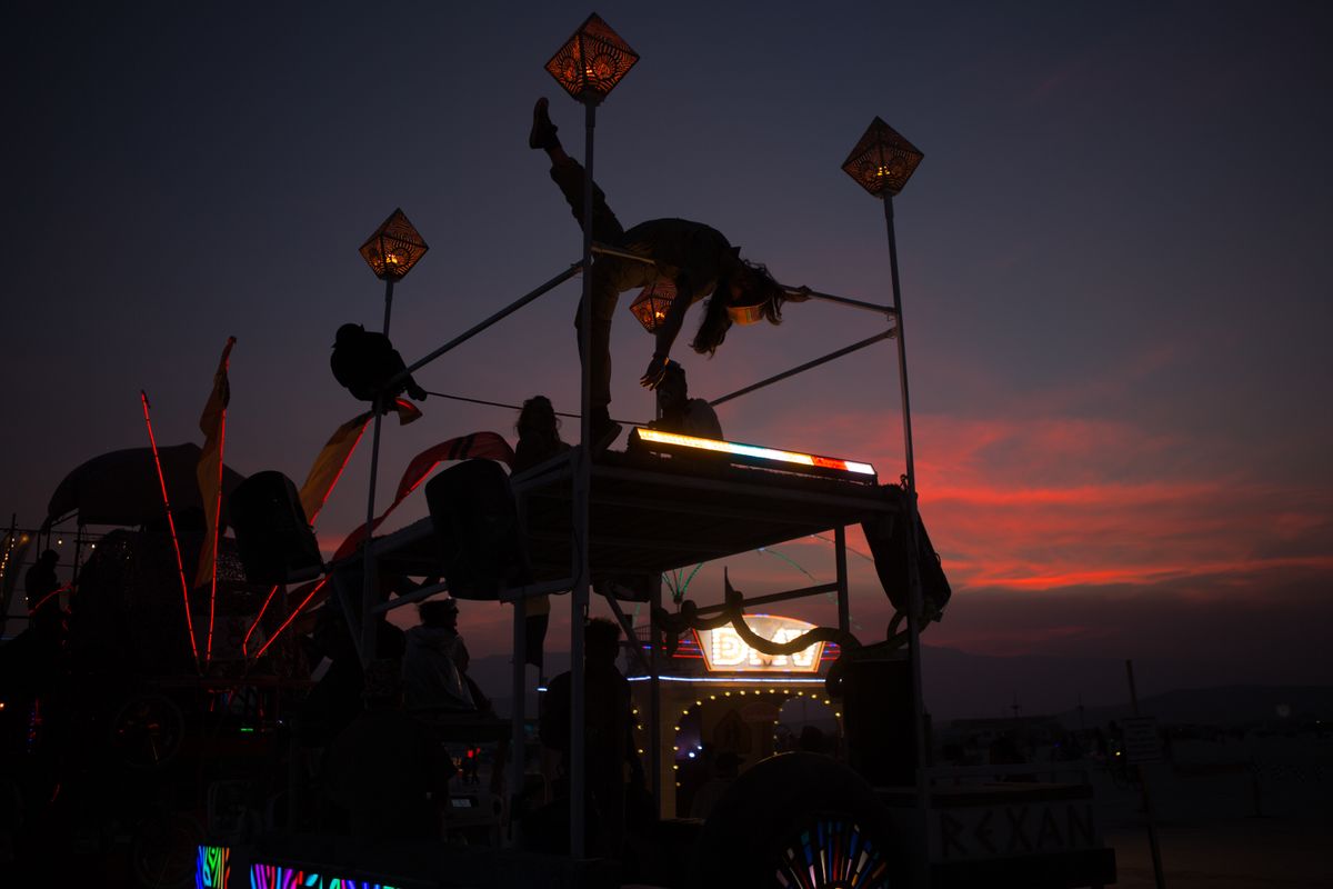 A dancer silhouetted on Rexan’s top rail against a red sunset